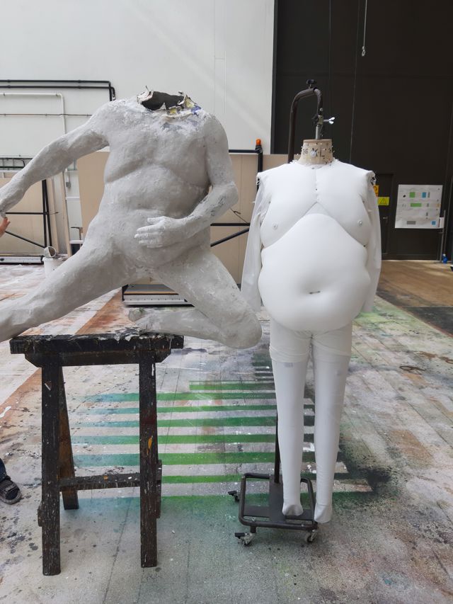 Leireskulptur ved siden av fatsuit