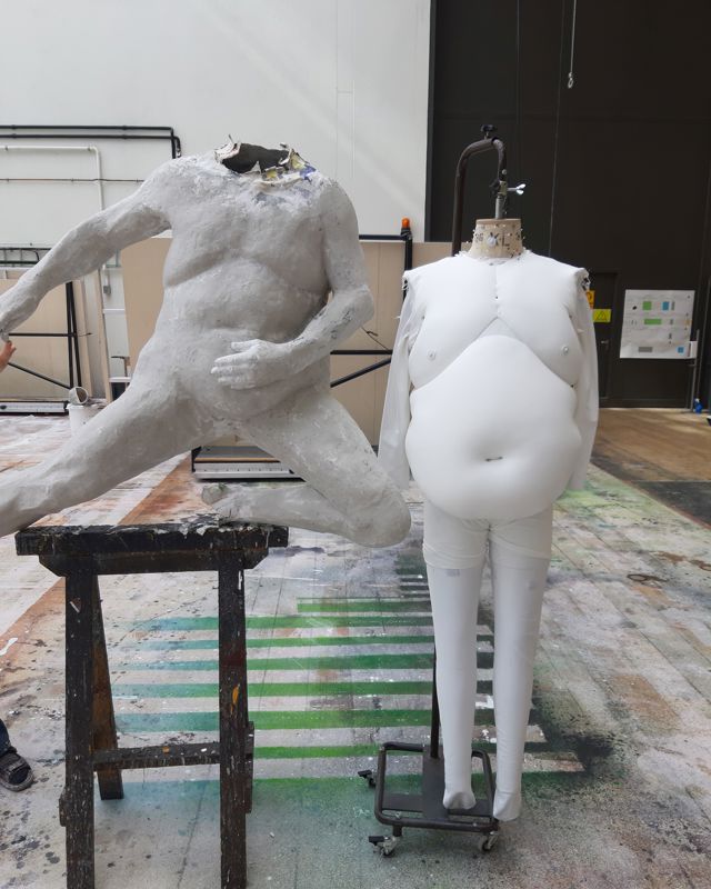 Leireskulptur ved siden av fatsuit
