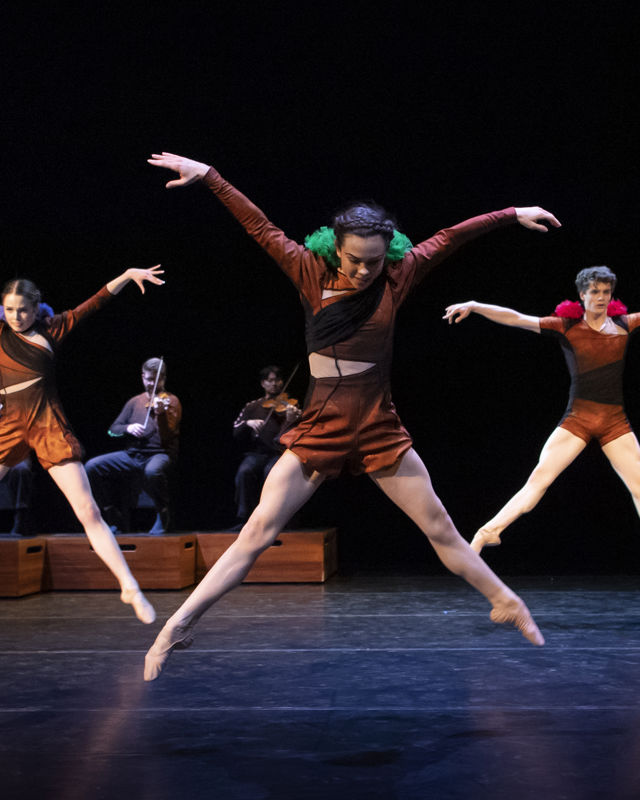 tre dansere og musikere i bakgrunnen
