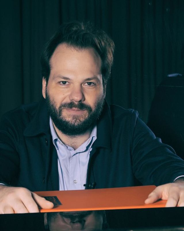 Mann med skjegg ser rett inn i kamera