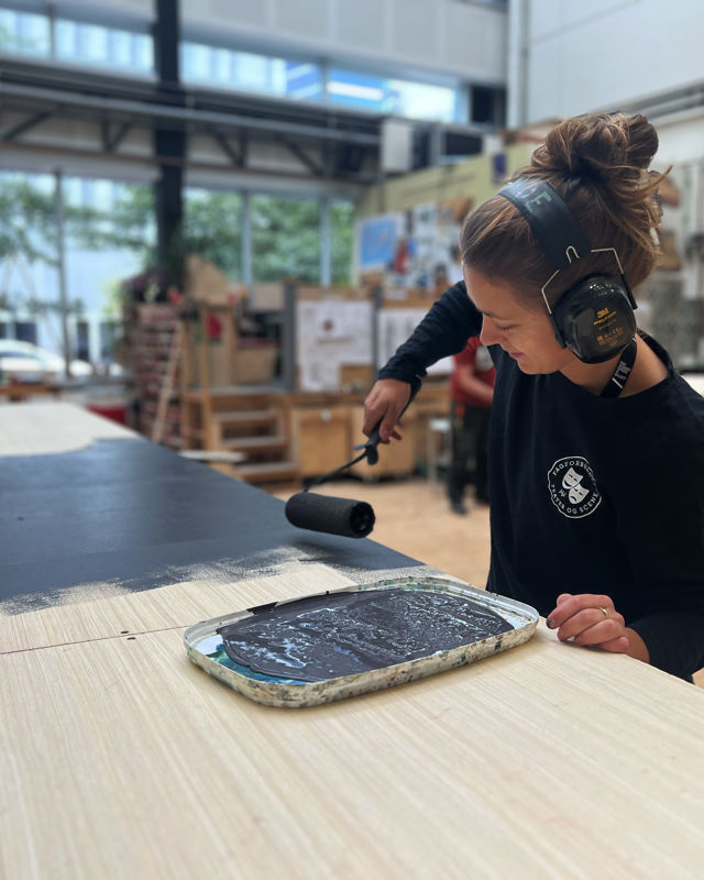 møbelsnekker Vilde maler meterialer på verkstedet