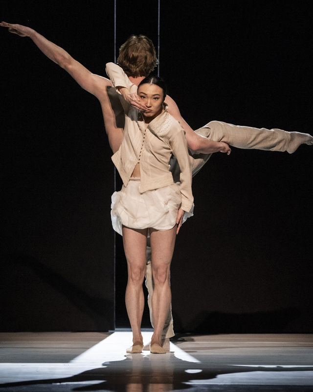 kvinne står foran mann som har ryggen til, han løfter opp ett ben