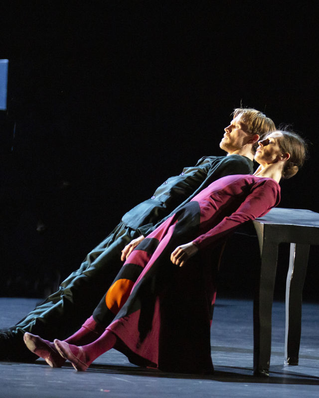 en mann og en kvinne lener ryggen mot et bord