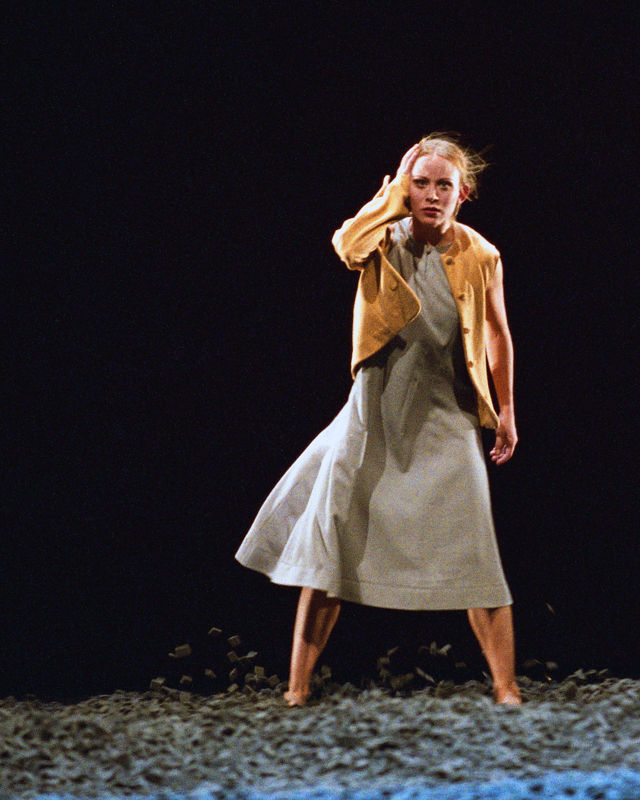 en ung kvinne i kjole og gul jakke