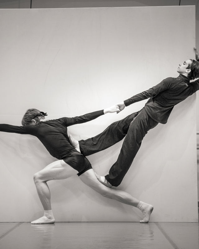 2 menn danser mot en hvit plate
