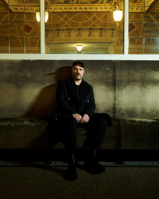 Mann sitter i stor sofa