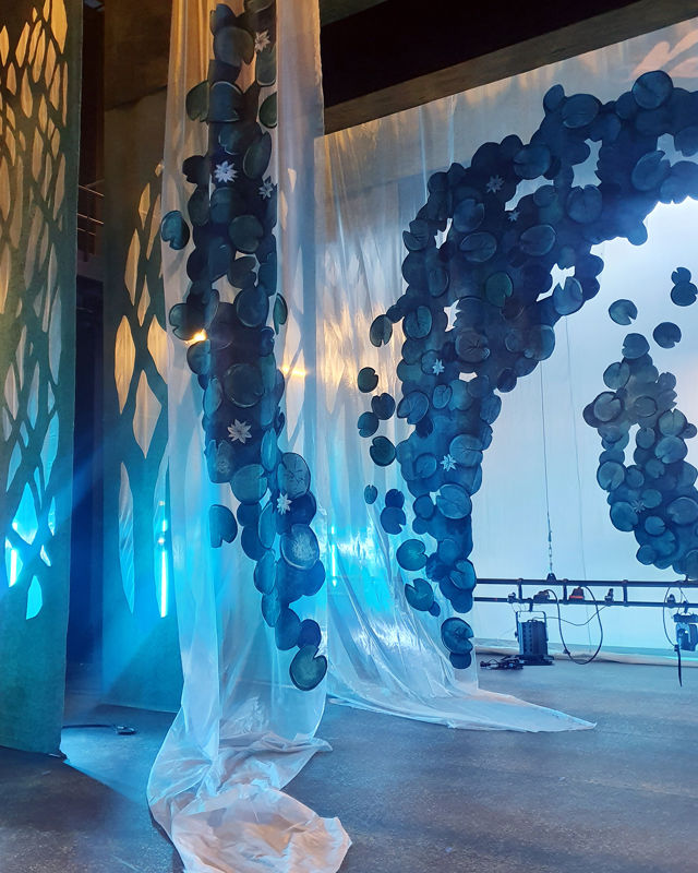 Scenografi – lag på lag med vannliljer i blåaktig lyssetting.