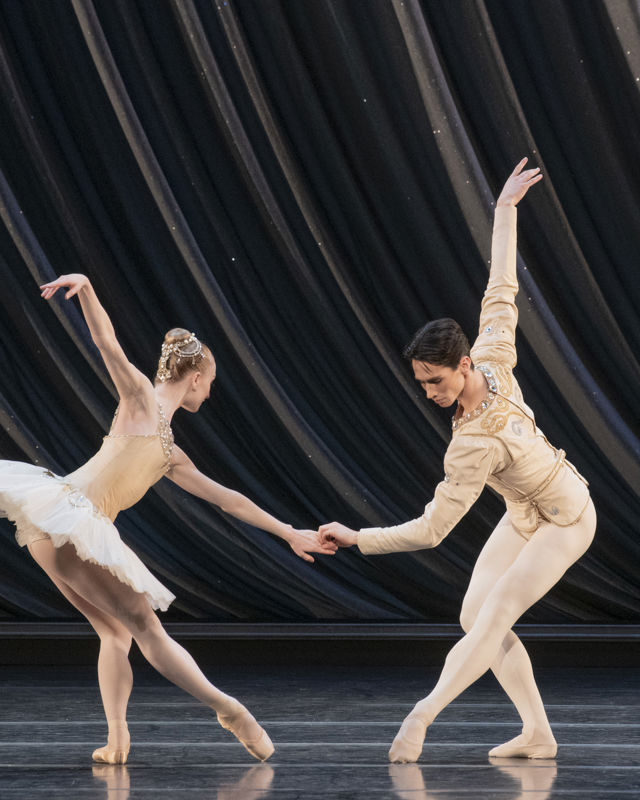 en mann og en dame danser ballett sammen, hun i hvit tutu og tåspissko