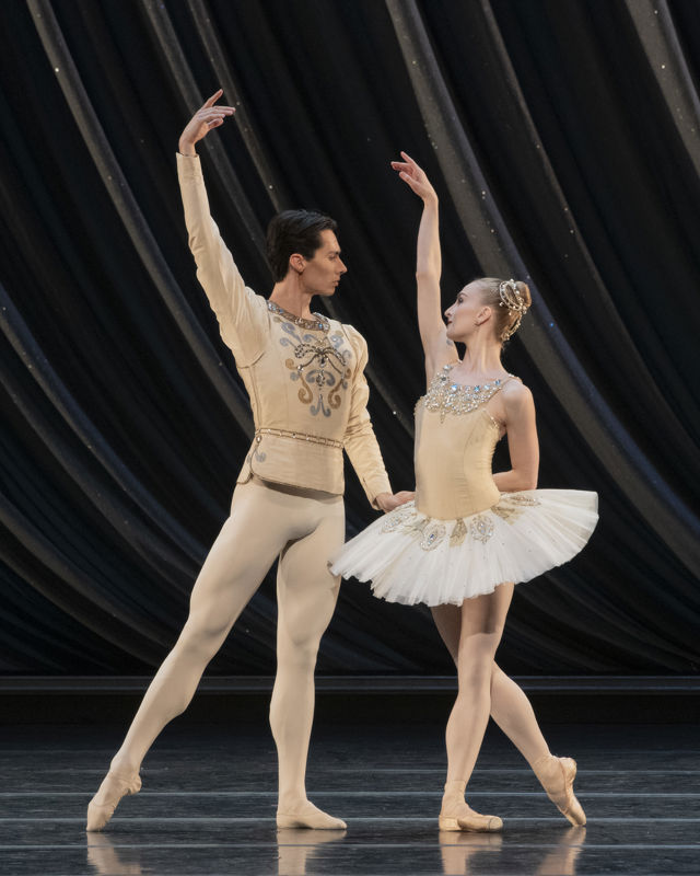 en mann og en dame danser ballett sammen, hun i hvit tutu og tåspissko