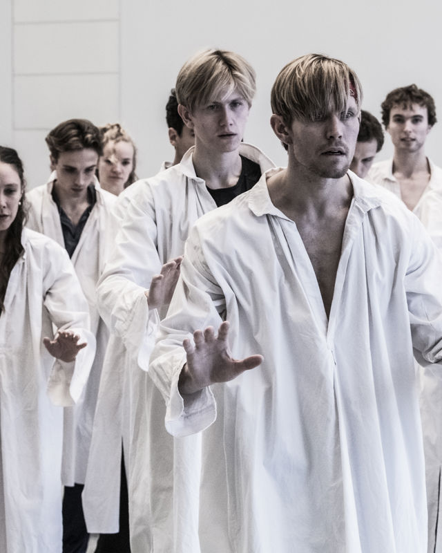 en gruppe med 14 dansere i hvite kjortler