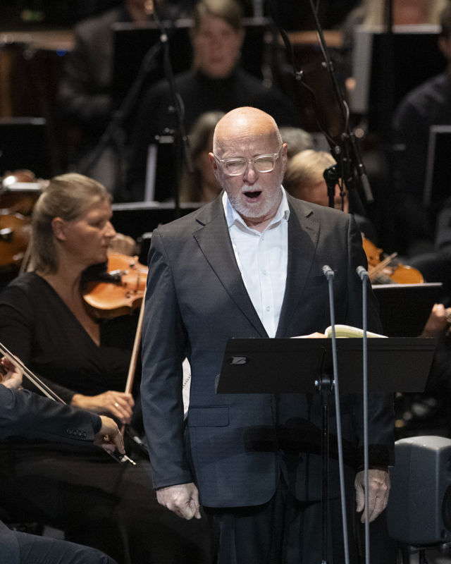 Mann som synger foran orkester