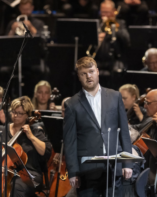 Mann foran orkestermusikere
