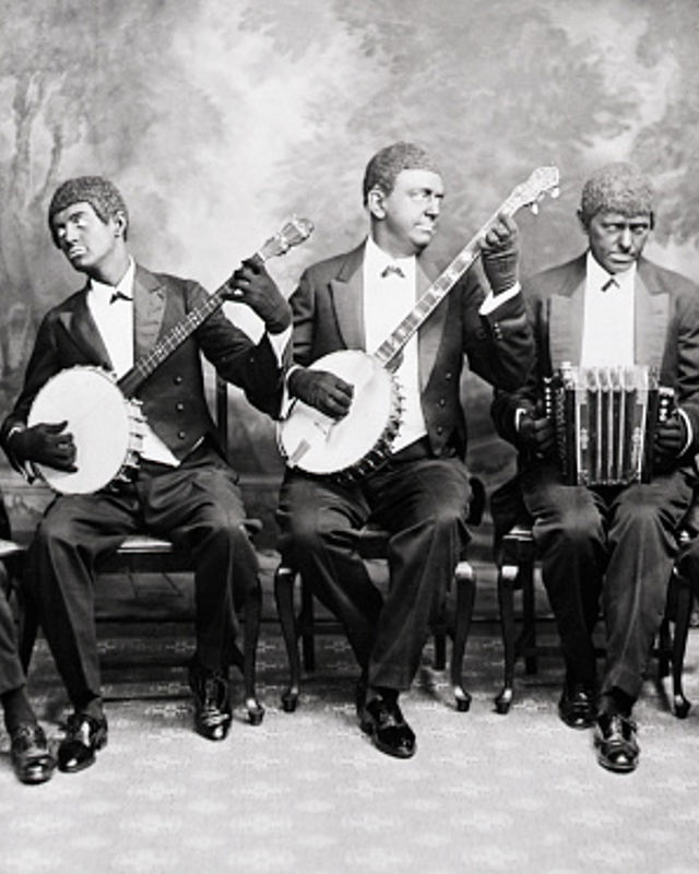 Flere menn med musikkinstrumenter malt mørke i ansiktet, gammelt foto