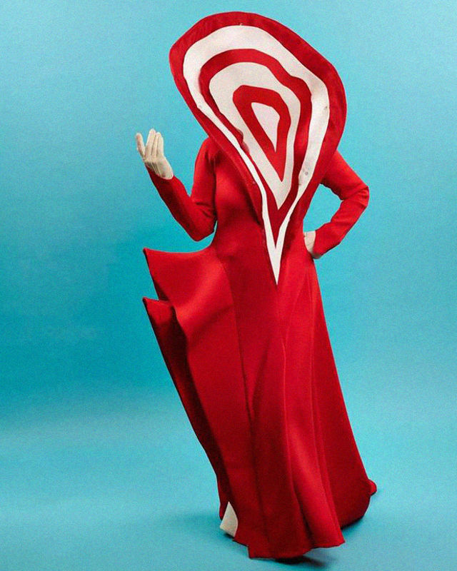 Dame i rød, lang kjole med stor fold i rød og hvit som skjuler ansiktet