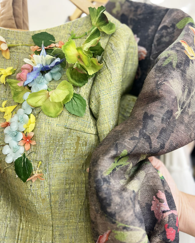 Bilde av detaljer fra grønt kostyme med blomster