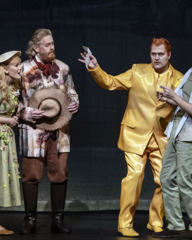 Mann i gul glinsende dress omgitt av eldre mann og yngre par