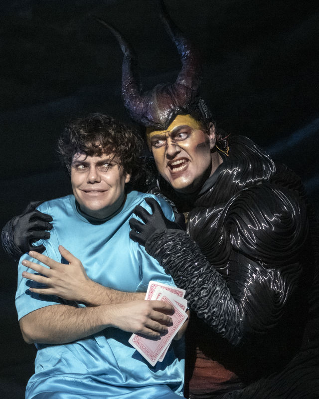 Mann i lyseblå trøye sammen med en som er utkledd i djevelkostyme