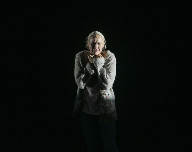 Portrett av bekymret kvinne mot svart bakgrunn